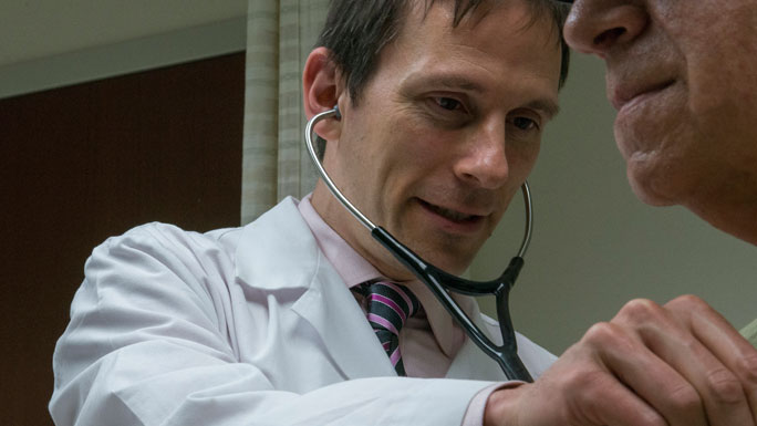 Andrew Artz, MD, medical oncologist, examines a patient