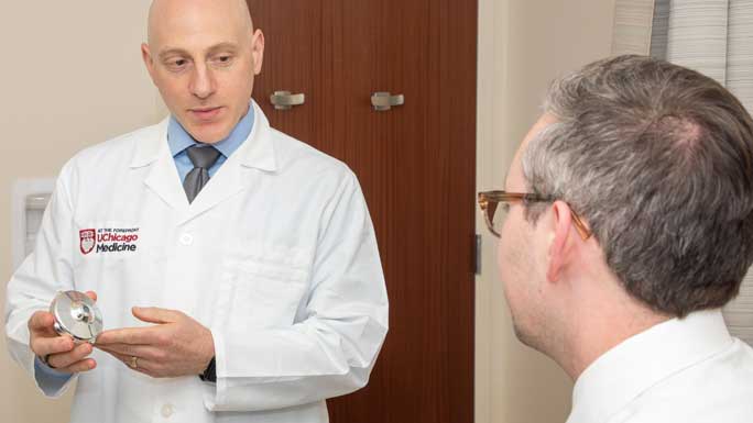 Surgeon Ryan Merkow, MD, holding an HAI device