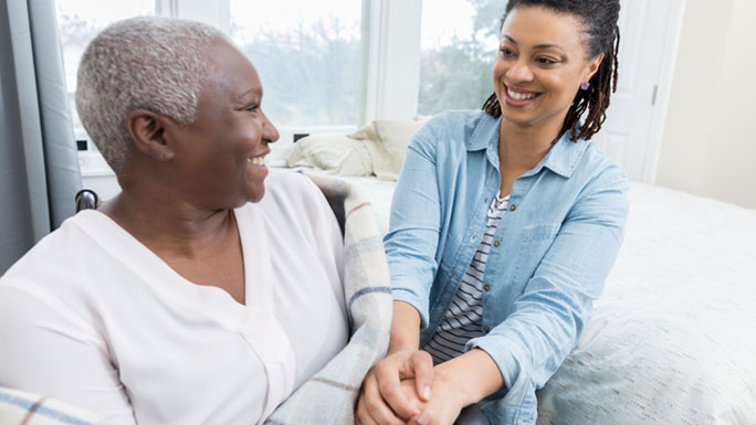older mother and daughter, at home, next to bed