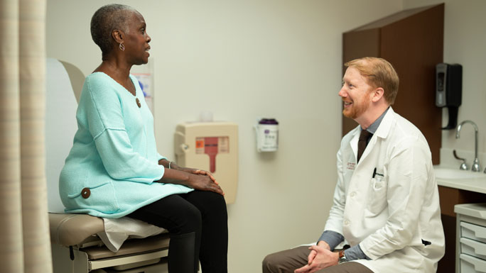 Dr. Alexander Pearson and female patient in clinic