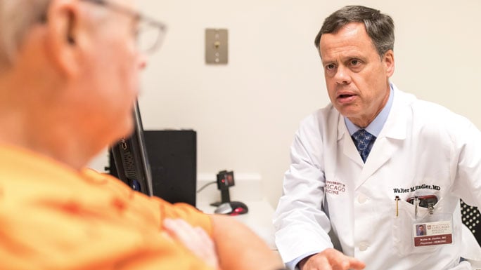 Medical oncologist Walter Stadler, MD, meeting with a patient in clinic