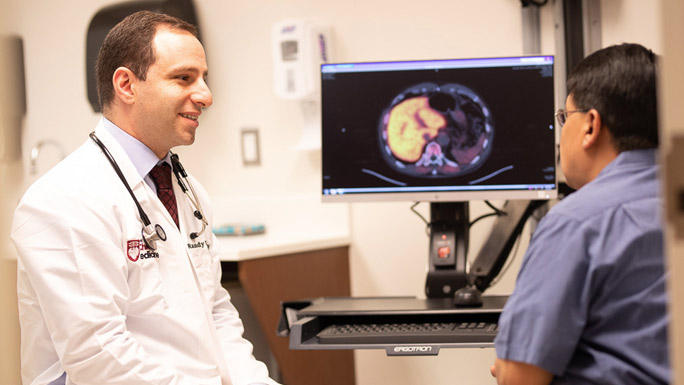 Randy Sweis, MD, in clinic with patient