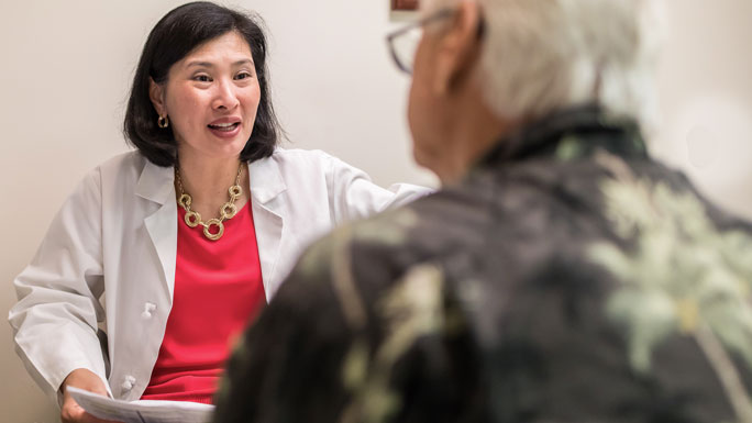 Hepatologist Helen Te, MD, and a patient in clinic