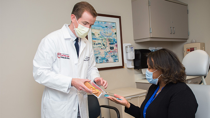 Image of Dr. Terence Imbery working with a cochlear implant patient