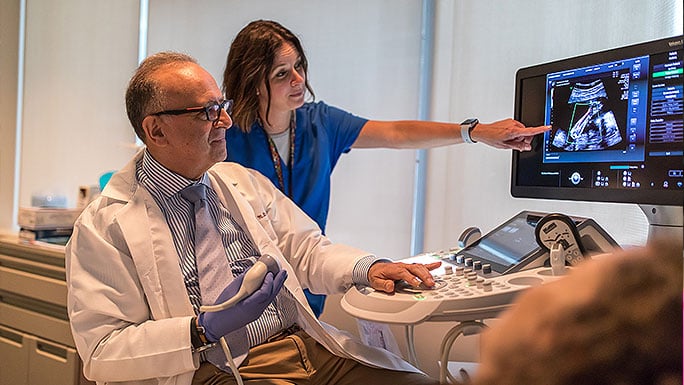 Obstetric ultrasound expert Dr. Jacques Abramowicz and nurse review a patient's during her appoinment