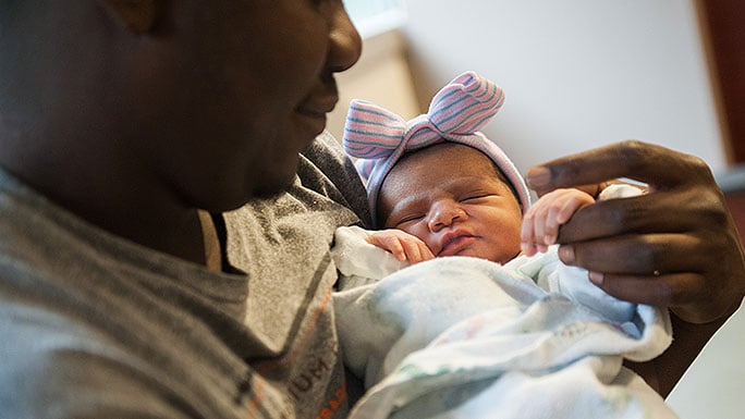 Dad cradles newborn girl