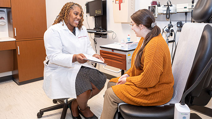 Certified nurse midwife Karie Stewart consults with a patient in Hyde Park