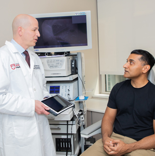 Philip LoSavio, MD with a male patient in a clinic room.