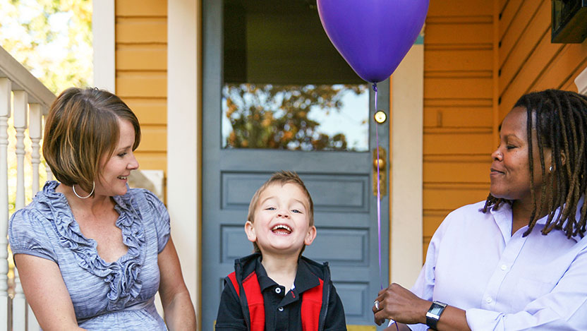 Two women smiling with their son