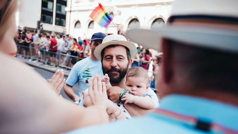 A man and his baby walking in a parade