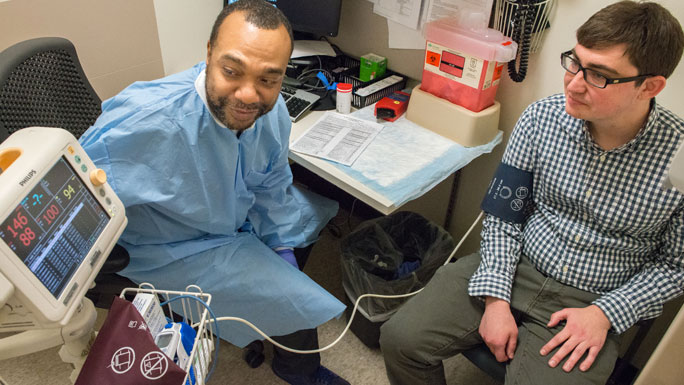 Terrance Collier, blood technician, checks the blood pressure of pathology resident Benjamin Kaumeyer, MD, in the DCAM blood donation clinic