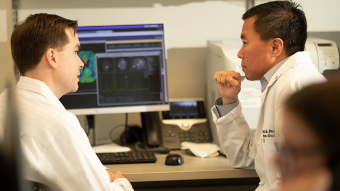 Radiologist John Collins, MD, and neuro-oncologist Deric Park, MD