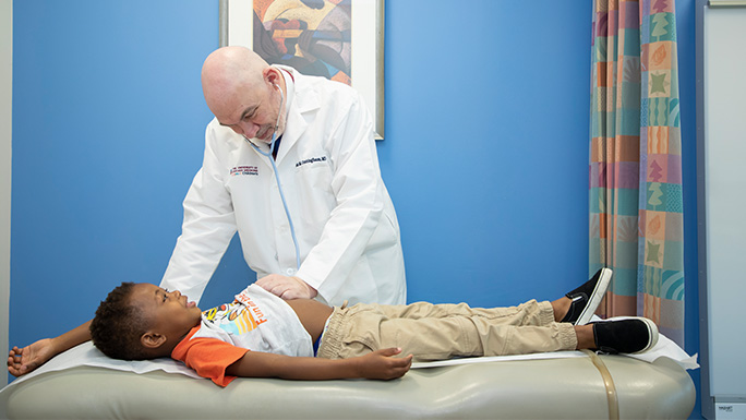 Image of Dr. Cunningham working with a childhood lymphoma patient