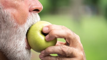 person biting into apple