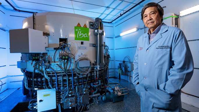 Chin-Tu Chen, PhD, standing in front of cyclotron