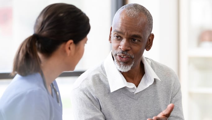 black male patient speaking to female nurse