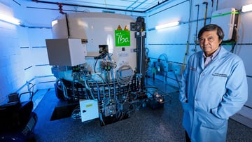 Chin-Tu Chen, PhD, stands alongside the IBA Cyclone 18 cyclotron 