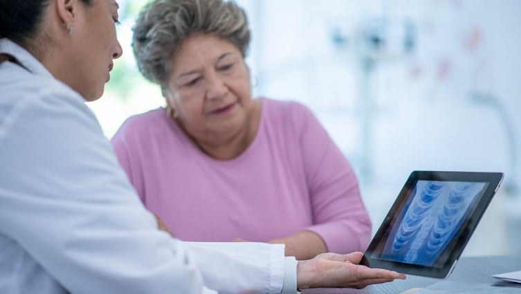 Female doctor showing lung scan to older female patient