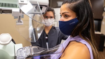woman in mask getting mammogram at River East Solis Mammography location