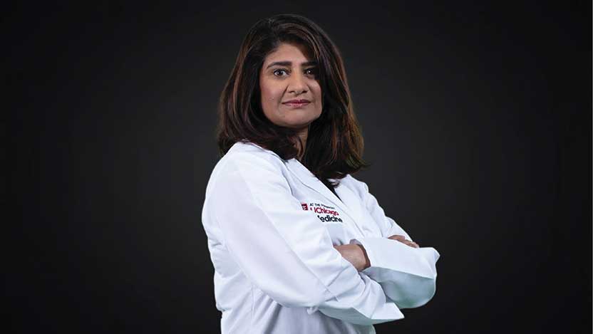 Doctor sitting on cabinet looking right, looking happy