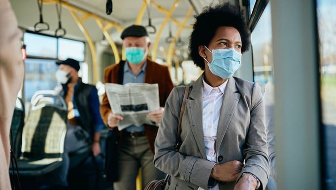 Pensive black businesswoman with face mask commuting by public transport