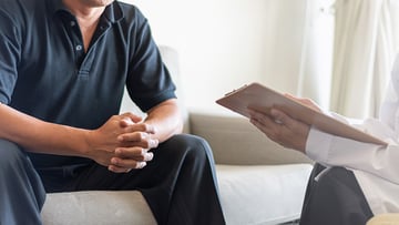 Doctor physician consulting with male patients in hospital exam room