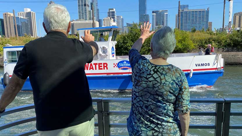 Man and woman waving at a passing ship