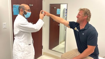 Dr. Naoum "Norm" Issa, MD, PhD, performs an exercise during a checkup to examine Kyle Pavlick