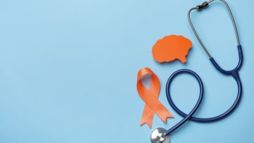 Orange ribbon, stethoscope and paper brain cutout on light blue background, flat lay with space for text. Multiple sclerosis awareness