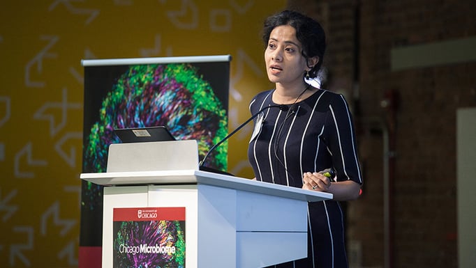 Oni Basu, PhD, speaking behind a podium.