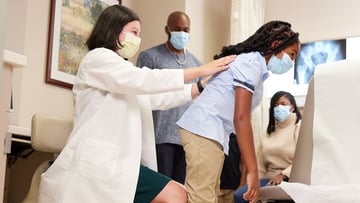 Dr. Clarabelle DeVries working with pediatric patient