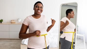 Woman measuring waist with tape