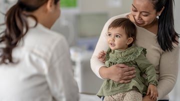 Image of pediatric doctor talking to parent and child about sleep training