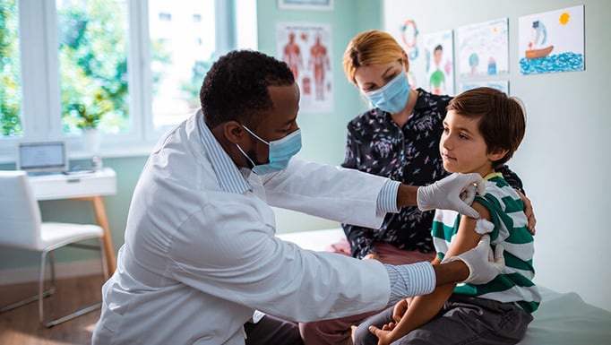 A child being vaccinated by a pediatrician.