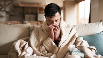person sneezing on couch