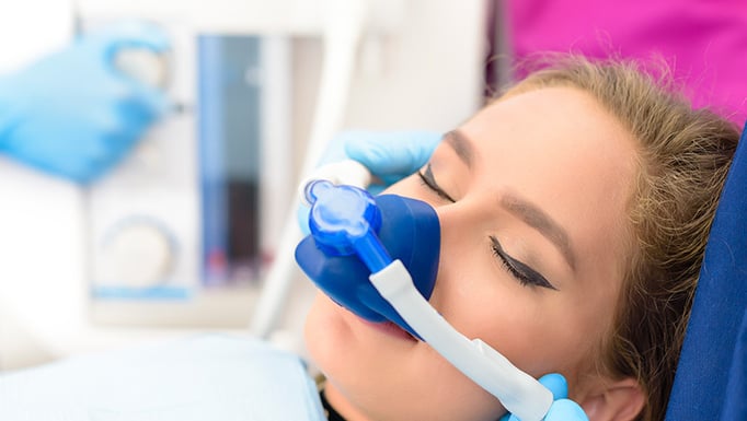 A woman with an inhalation mask over her mouth and nose.