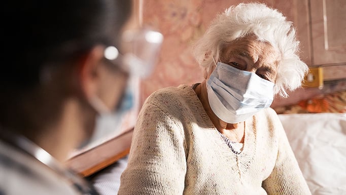 Female doctor doing medical exam of a senior woman at her home.