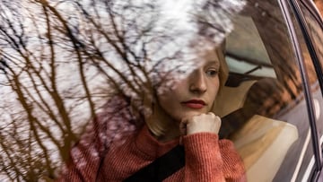 Woman staring out of car window in deep thought