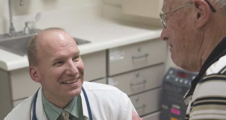 William Dale, MD, meets with a patient