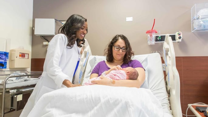 Carissa Abrego-Collier snuggles her newborn Marina while a midwife at the University of Chicago Medicine Family Birth Center looks on.