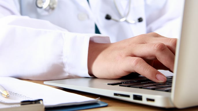 Doctor typing on a laptop