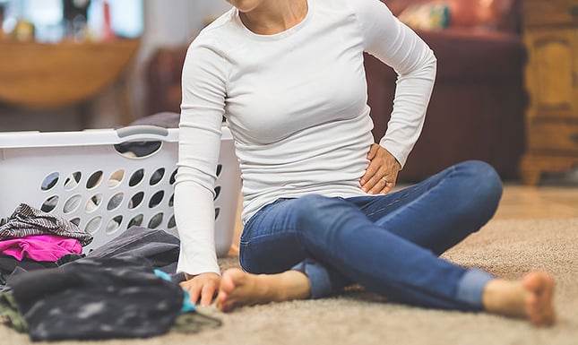 Woman feeling pelvic pain with hand on abdomen