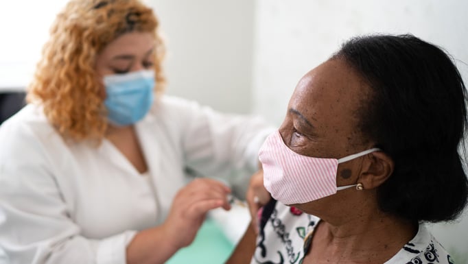 Clinician provides a vaccine to a patient
