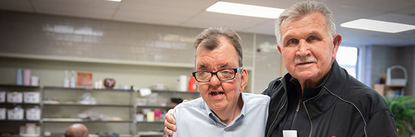 Mike Ditka with his arm around a Misericordia resident