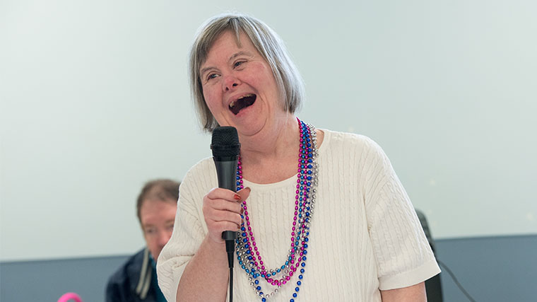 Image of a Misericordia resident singing into a microphone