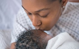 Mom kisses newborn