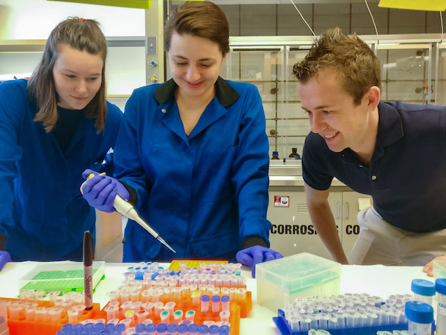 Bryan Dickinson (right) discussing research with graduate students Kaitlin Kentala (left) and Simone Rauch (middle).