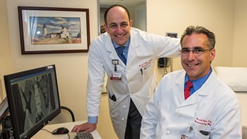 David Rubin, MD, and Russell Cohen, MD, in an office with a computer
