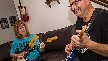 Jean Martinez plays guitar with her husband after treatment for Parkinson