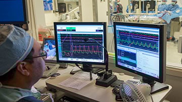 Physician looking at a computer screen observing the OR